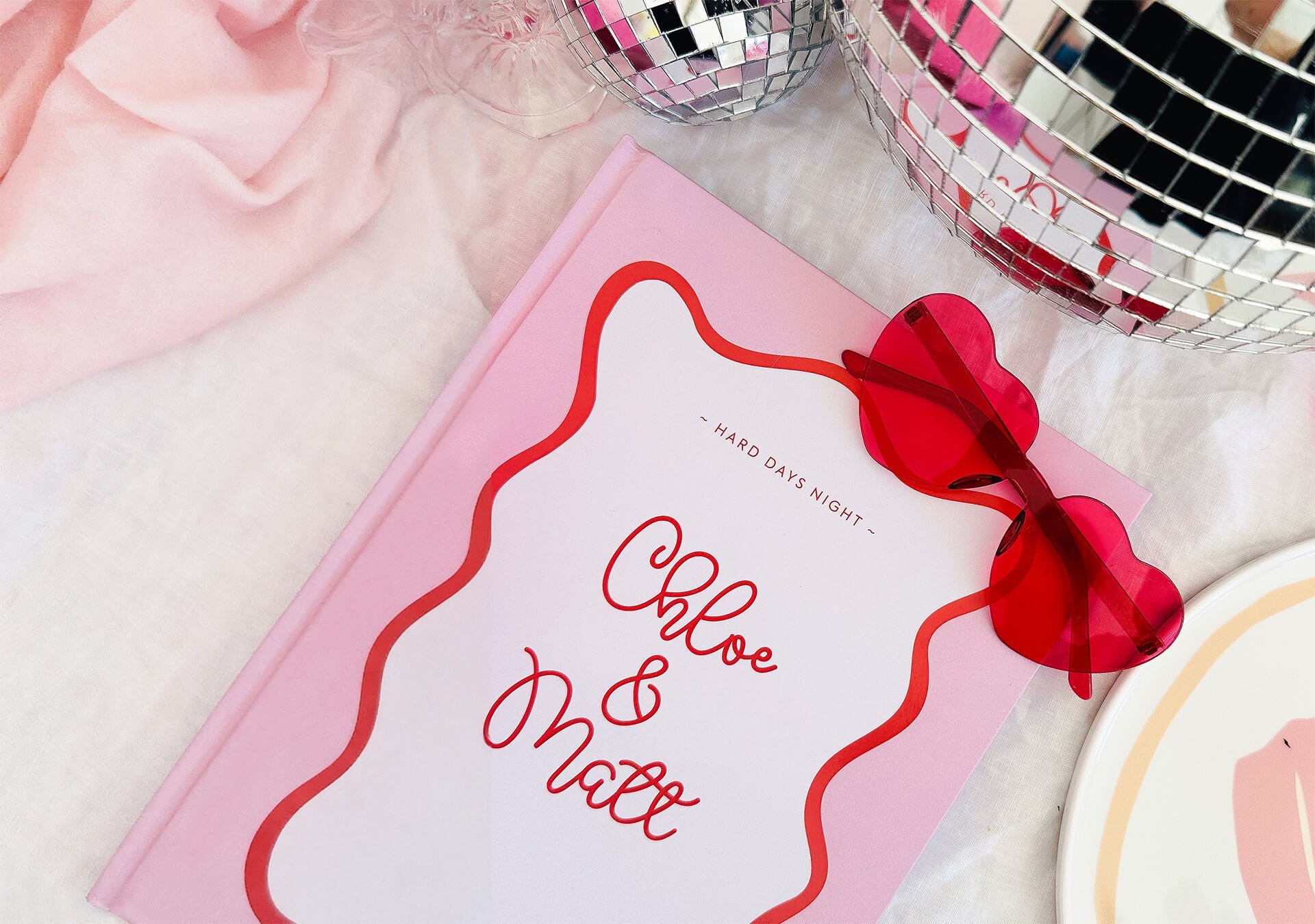 Personalised wedding polaroid book with polaroid photos scattered to the side, along with a gold pen