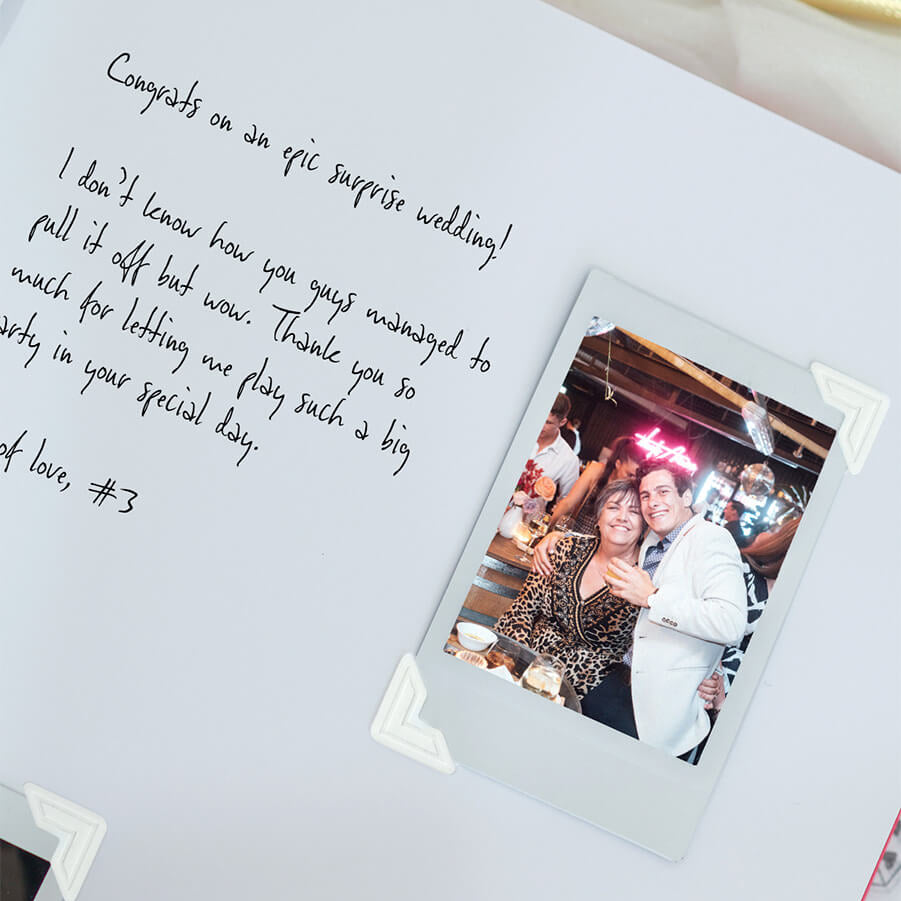 Polaroid photo of a couple at a party with handwritten congrats message on a white background
