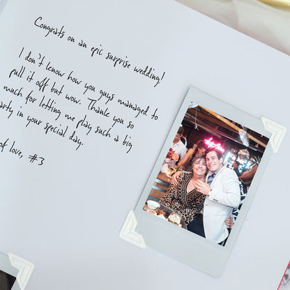 Polaroid photo of a couple at a party with handwritten congrats message on a white background