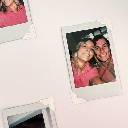 Two instax photos of a couple on a blank guest book